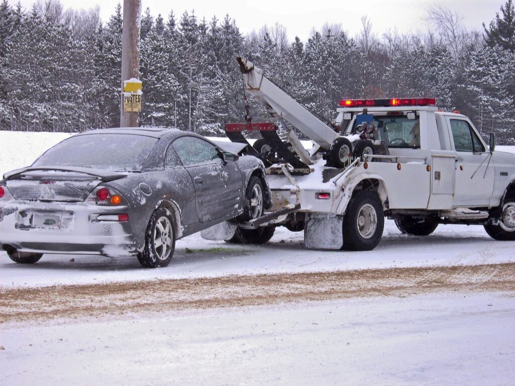 derry personal injury services, picture of a car being towed after a snowy car accident 